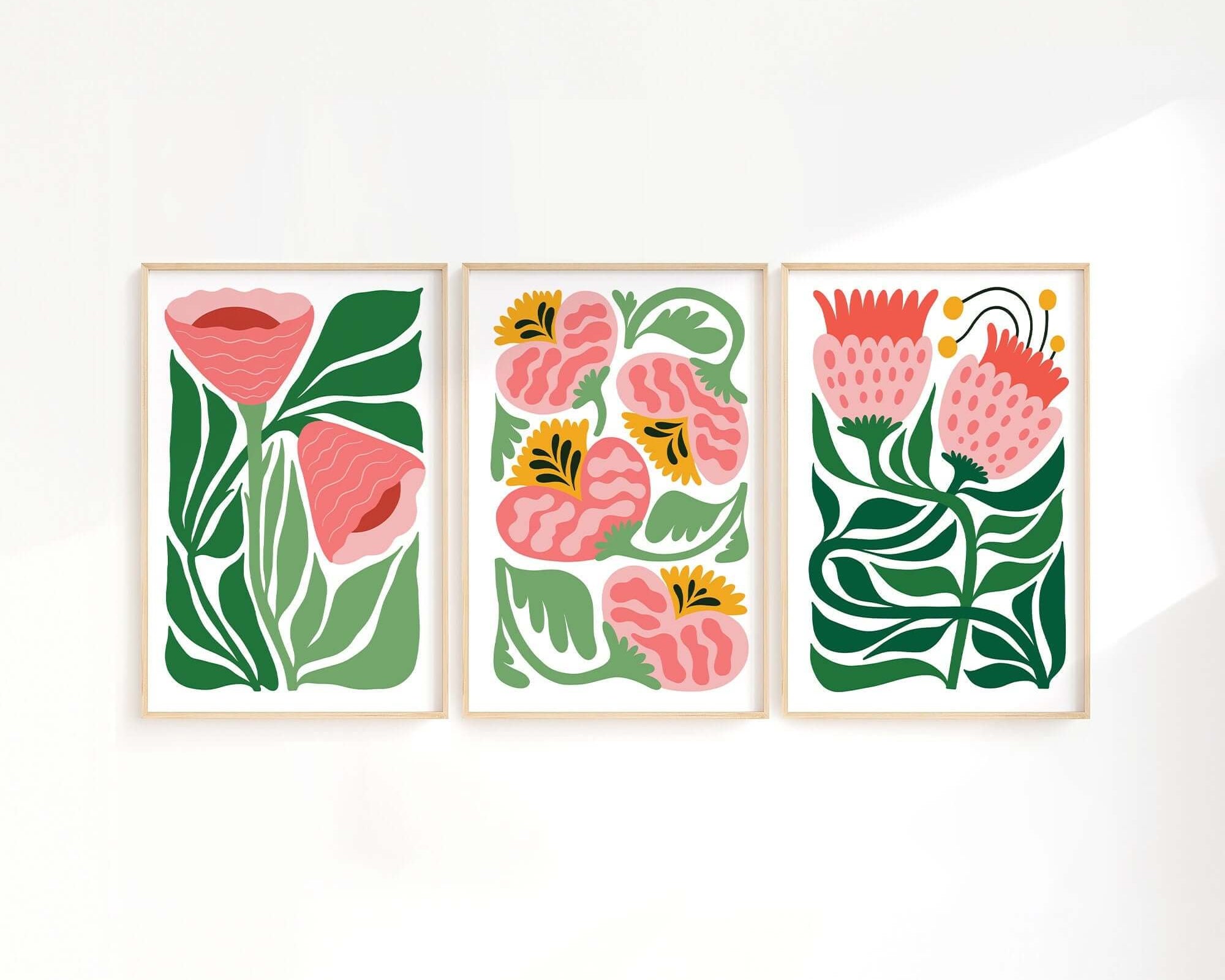 The Tropical Blocks Triptych (Set of Three Prints | 406) features abstract floral designs with green leaves and pink flowers, ideal for adding style and elegance to your home decor.