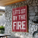 a red sign that says let's sit by the fire