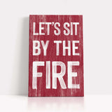 a red sign that says let's sit by the fire