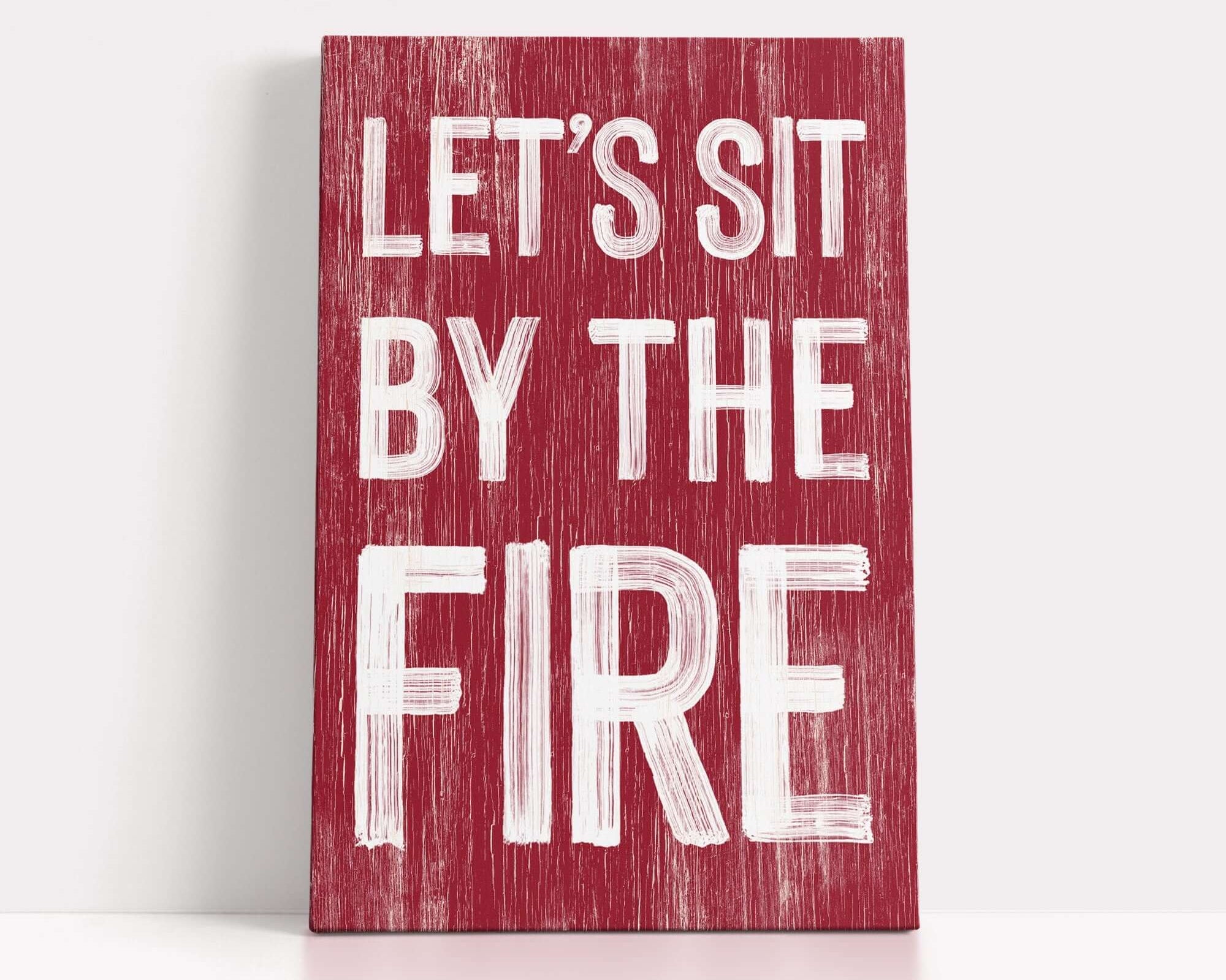 a red sign that says let's sit by the fire