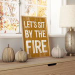 a wooden sign that says let's sit by the fire