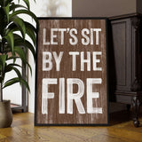 a wooden sign that says, let's sit by the fire