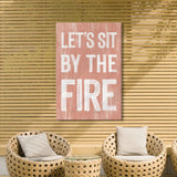 a living room with wicker chairs and a pink sign