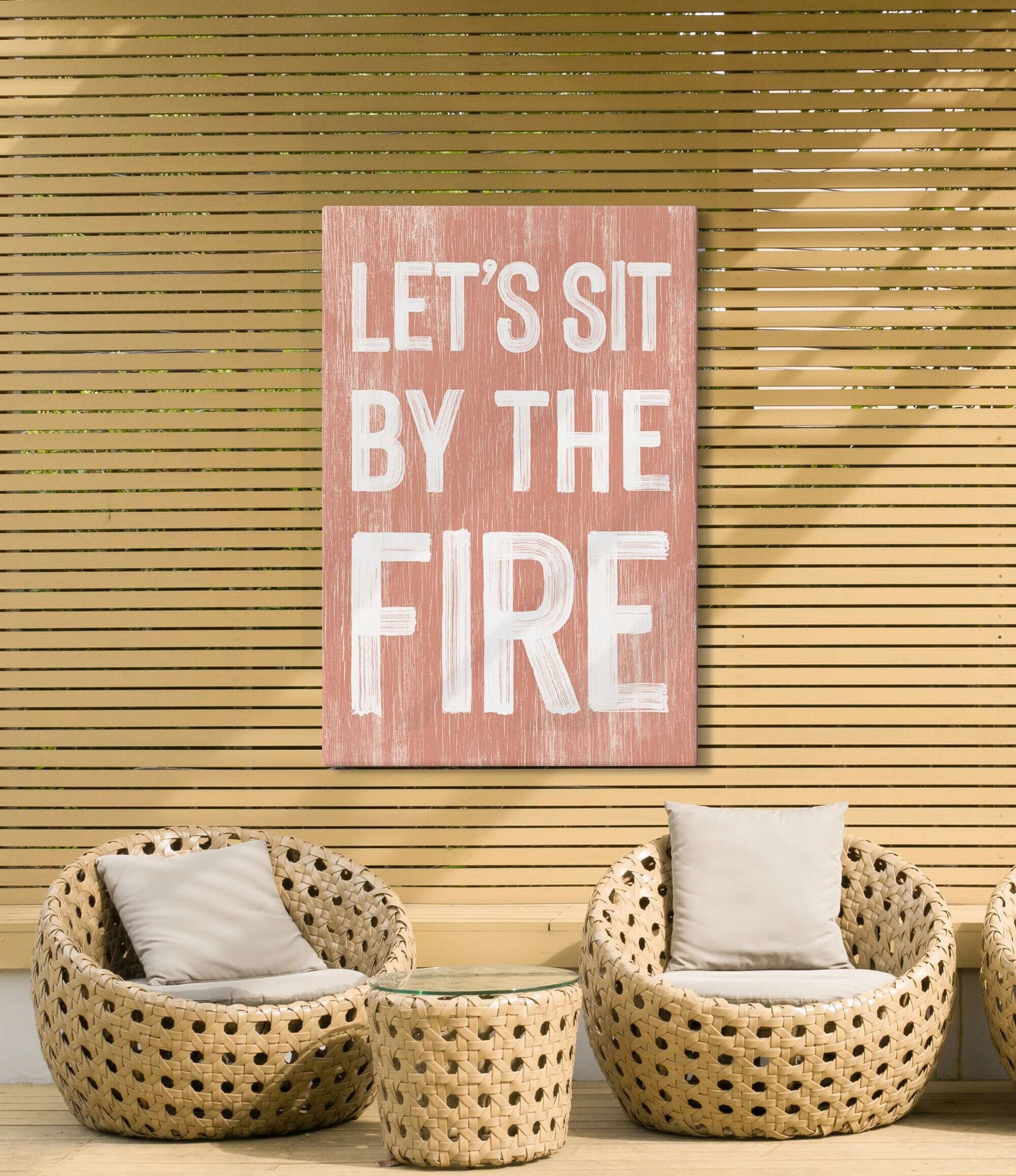 a living room with wicker chairs and a pink sign