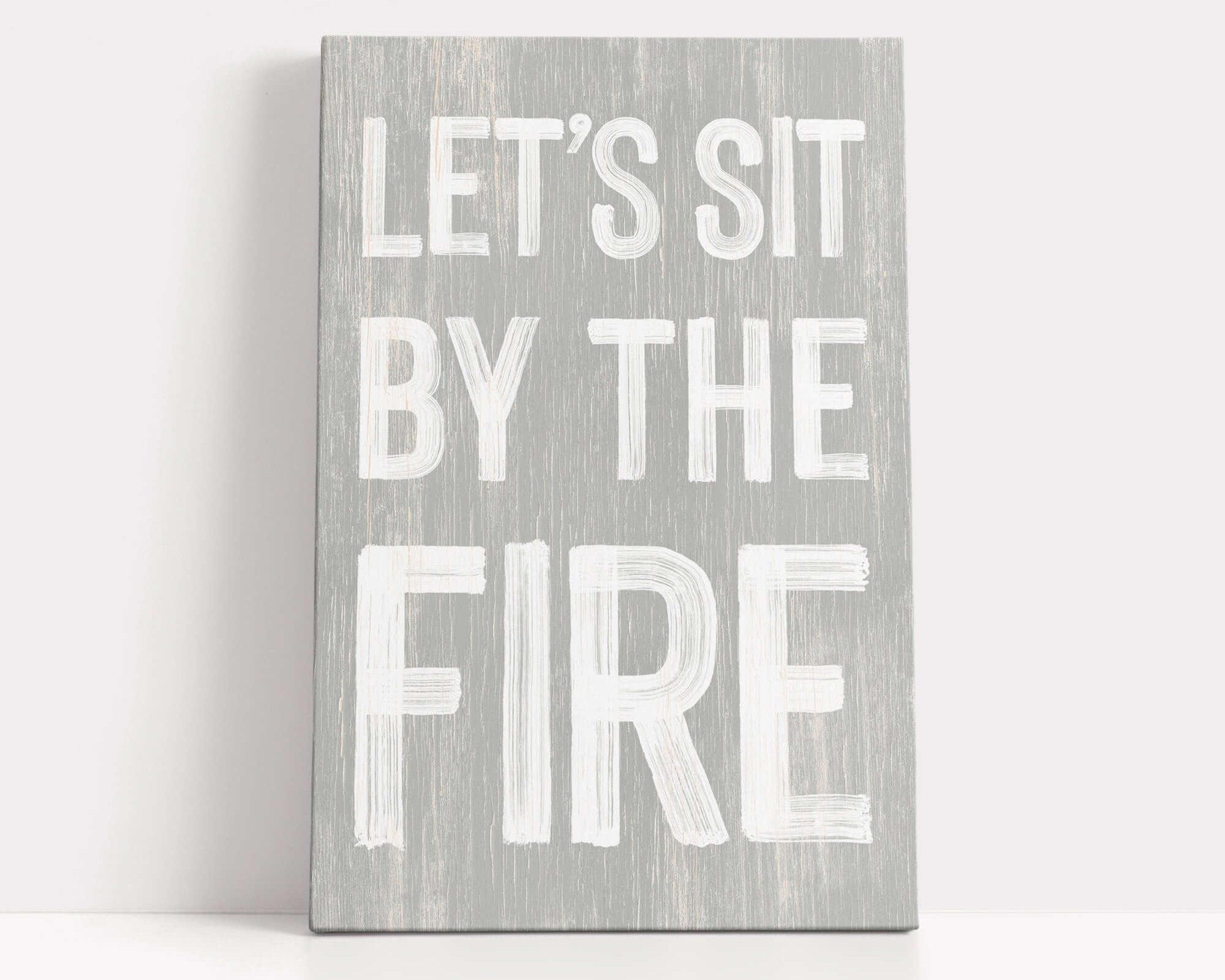 a wooden sign that says let's sit by the fire