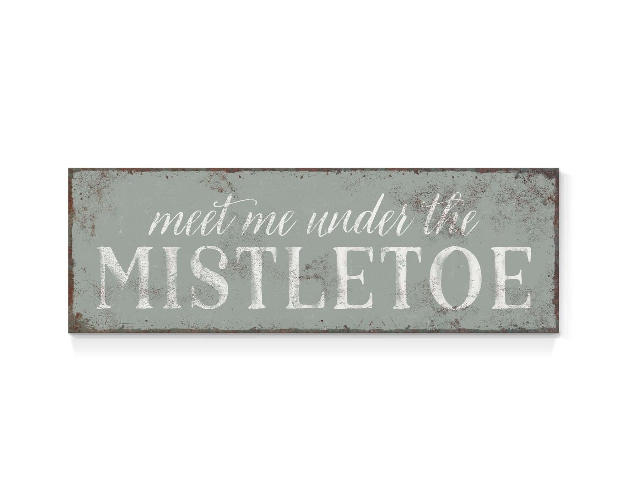 a metal sign that says meet me under the mistletoe