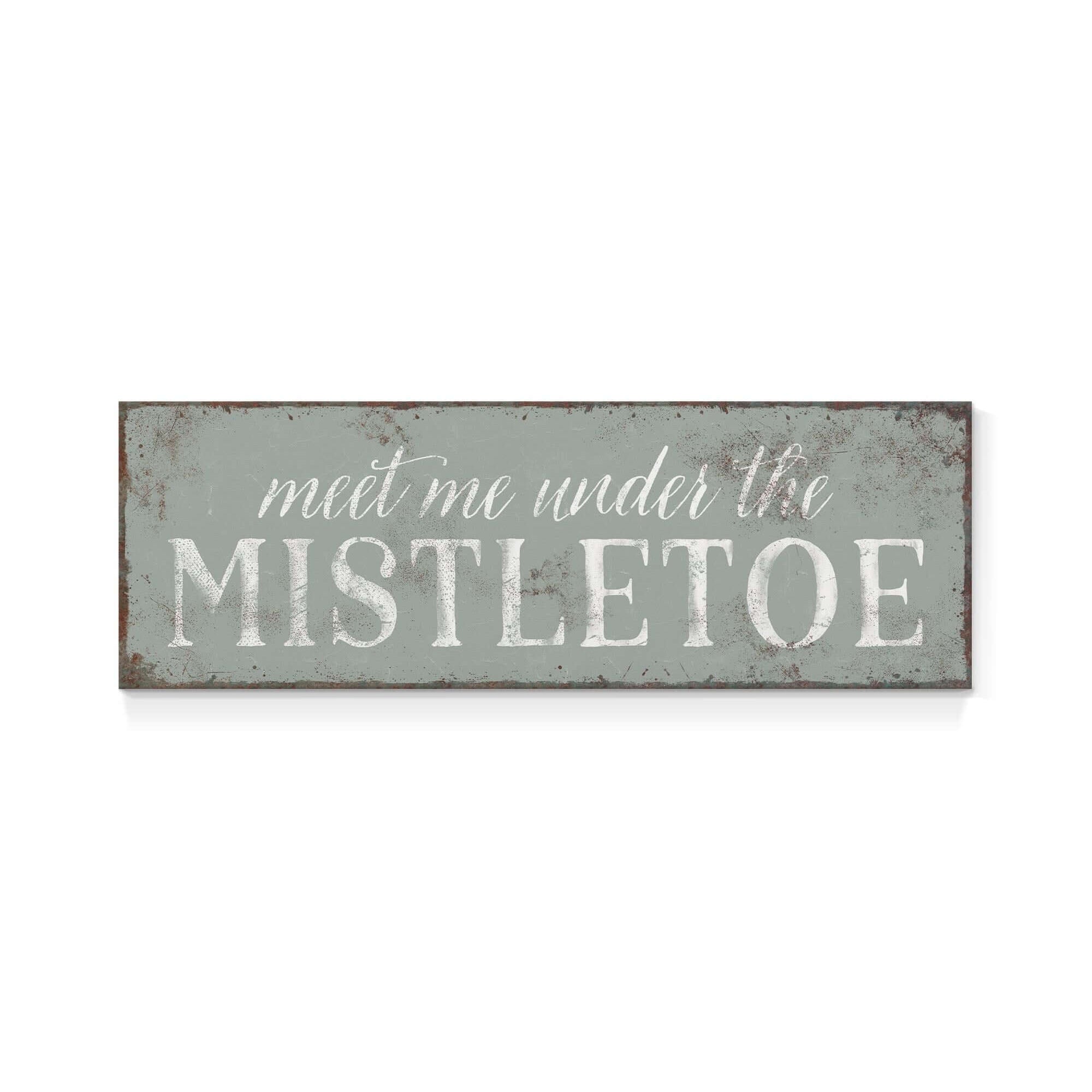 a metal sign that says meet me under the mistletoe
