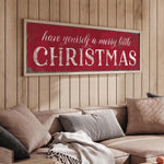 a living room with a couch and a christmas sign on the wall