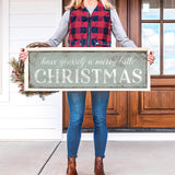 a woman holding a sign that says have yourself a merry little christmas