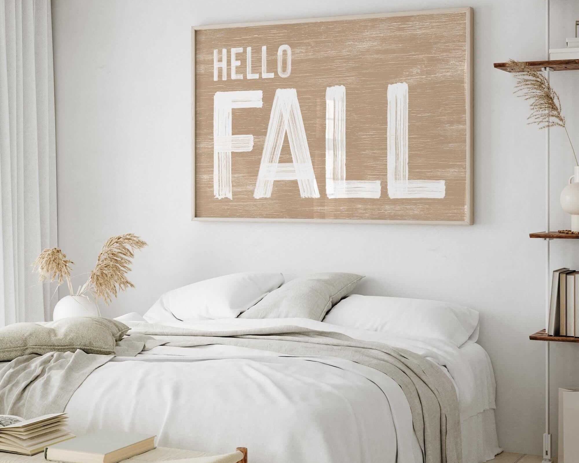 a bedroom with a white bed and a hello fall sign on the wall