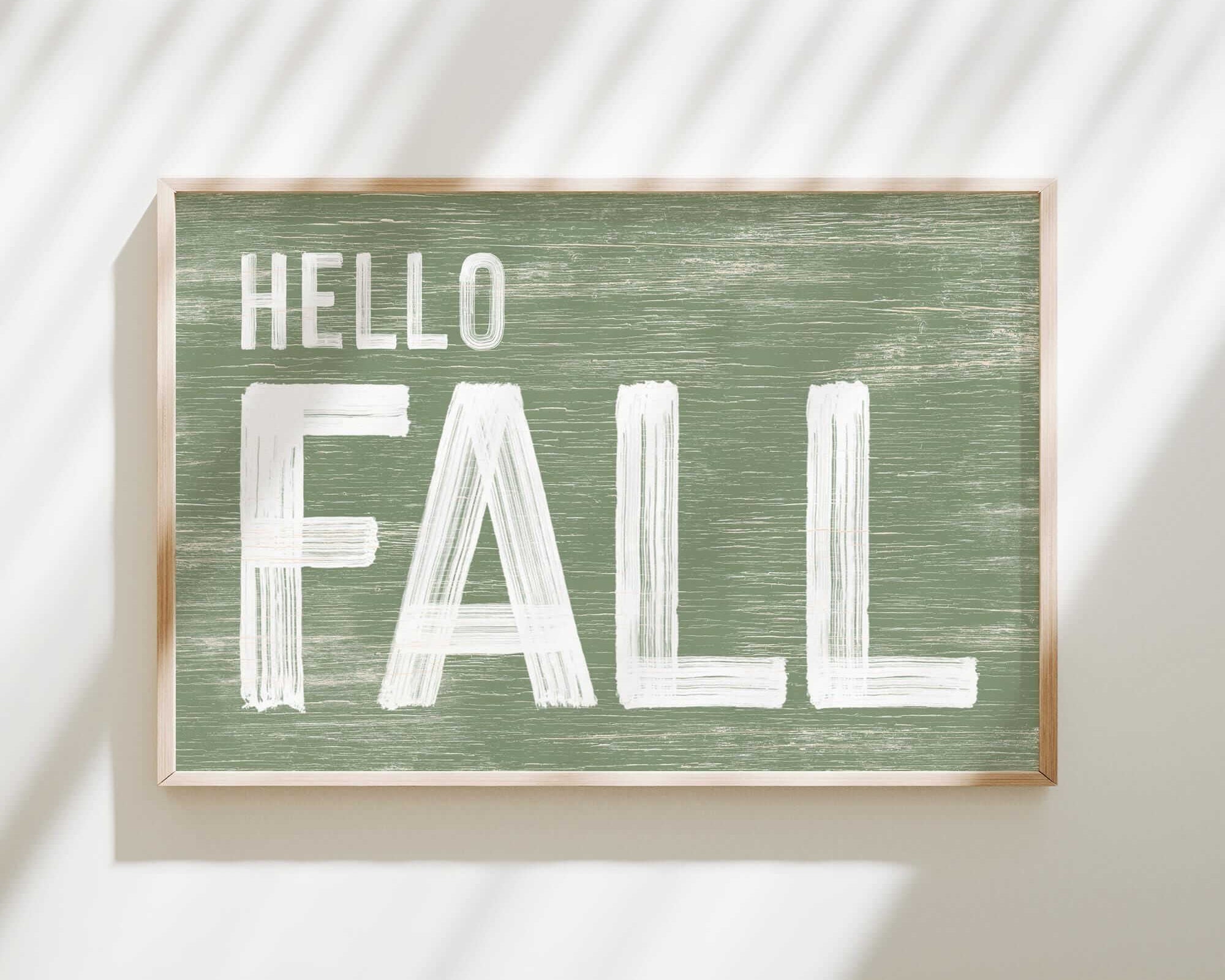 a green sign that says hello fall hanging on a wall