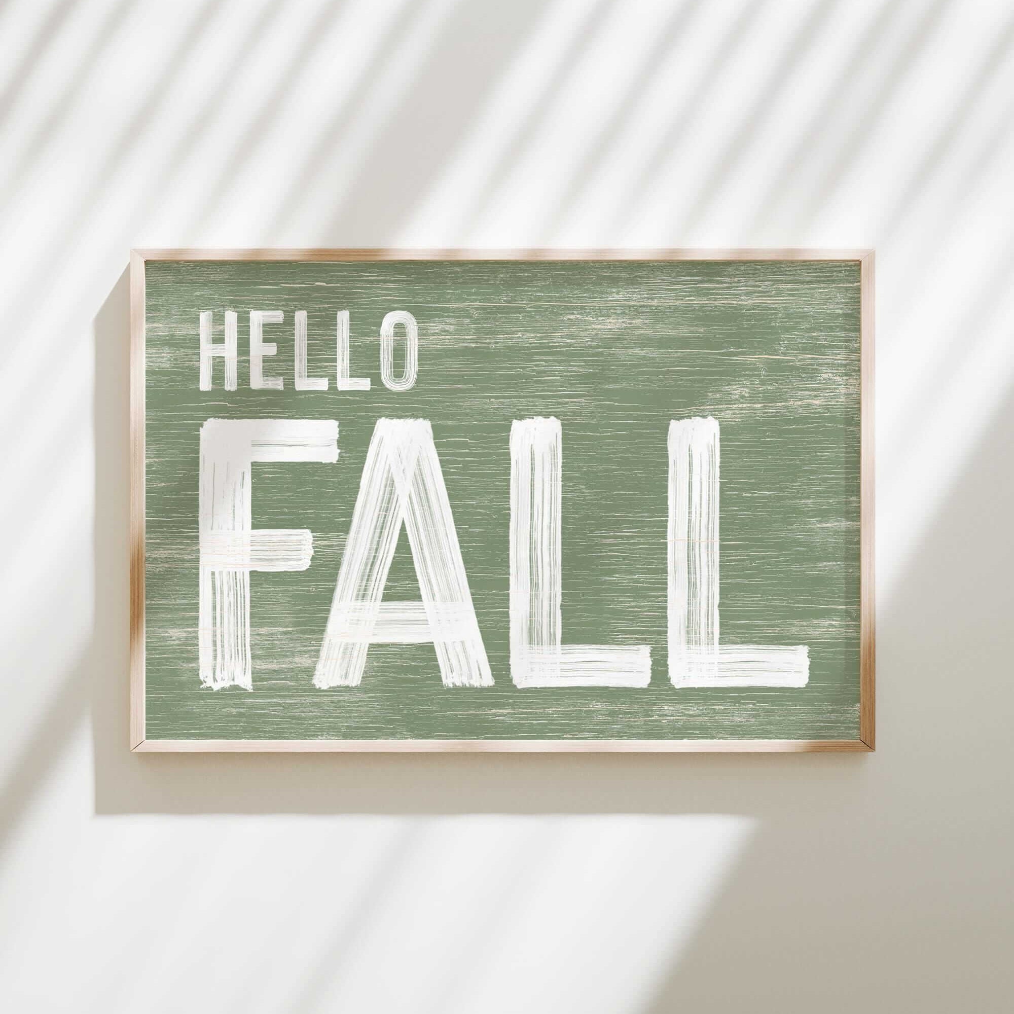 a green sign that says hello fall hanging on a wall