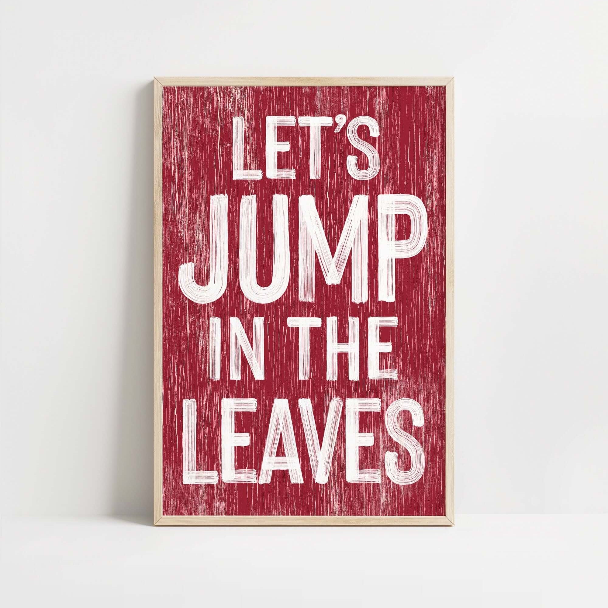 a red sign that says let&#39;s jump in the leaves