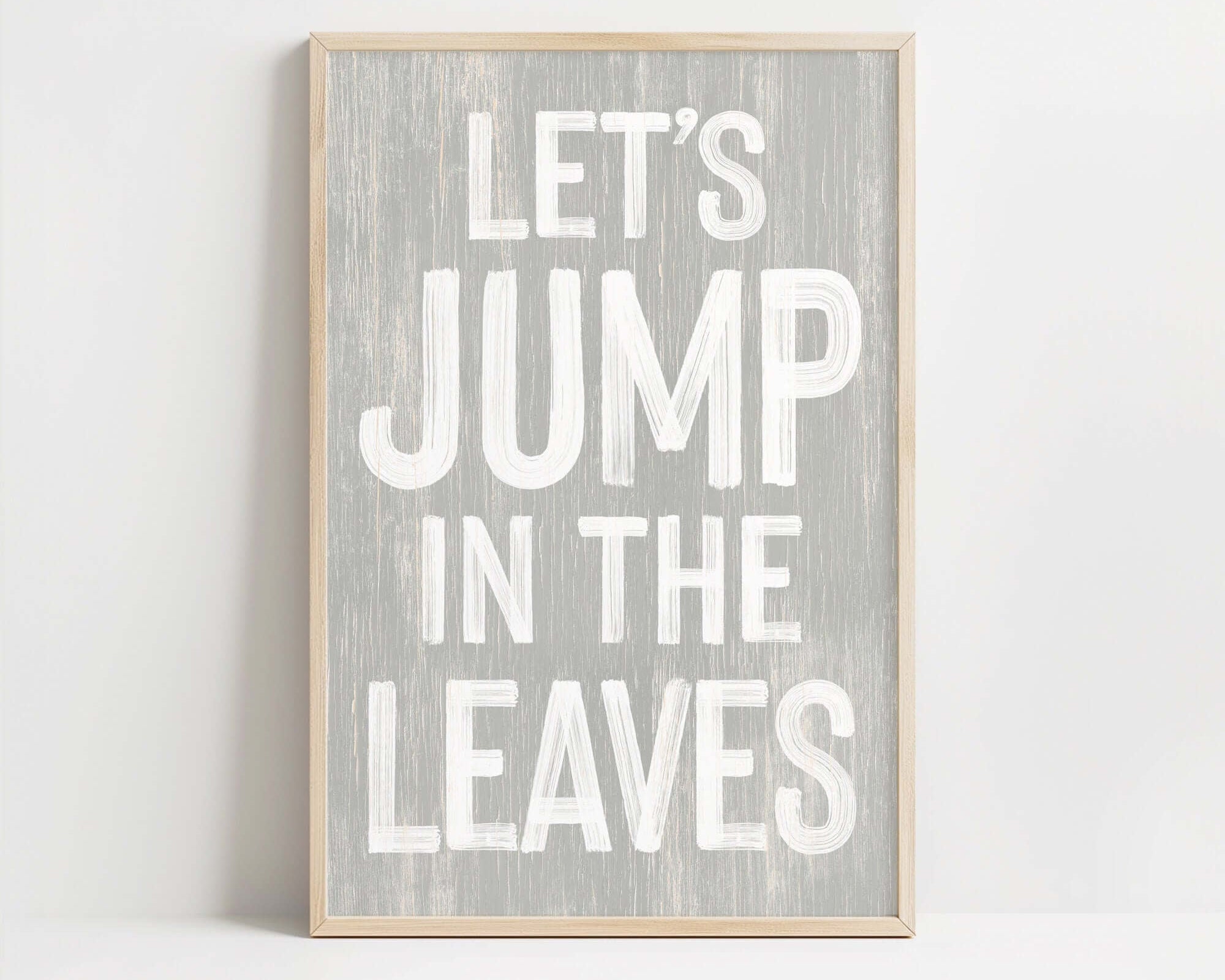 a wooden sign that says let's jump in the leaves