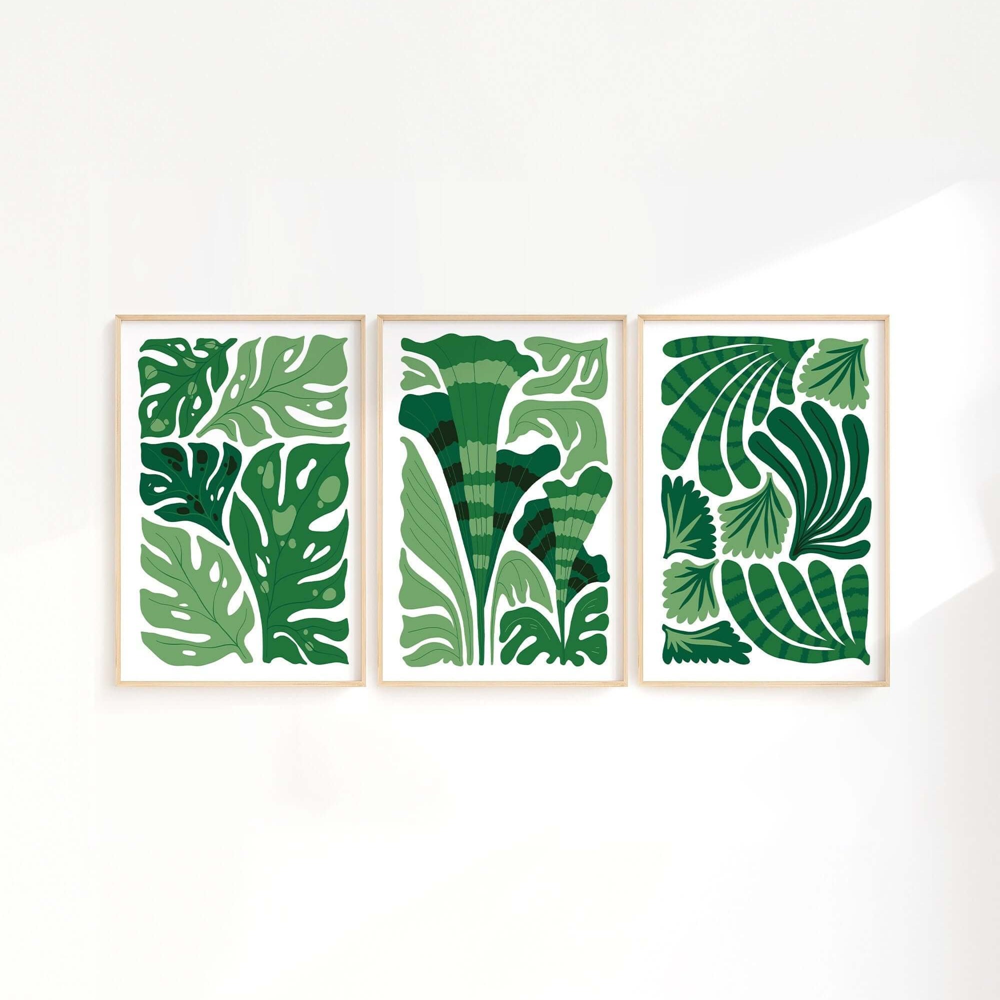 Enhance your space with the Tropical Blocks Triptych (Set of Three Prints | 401)—a trio of framed art prints displaying abstract green leaf designs on a crisp white background.