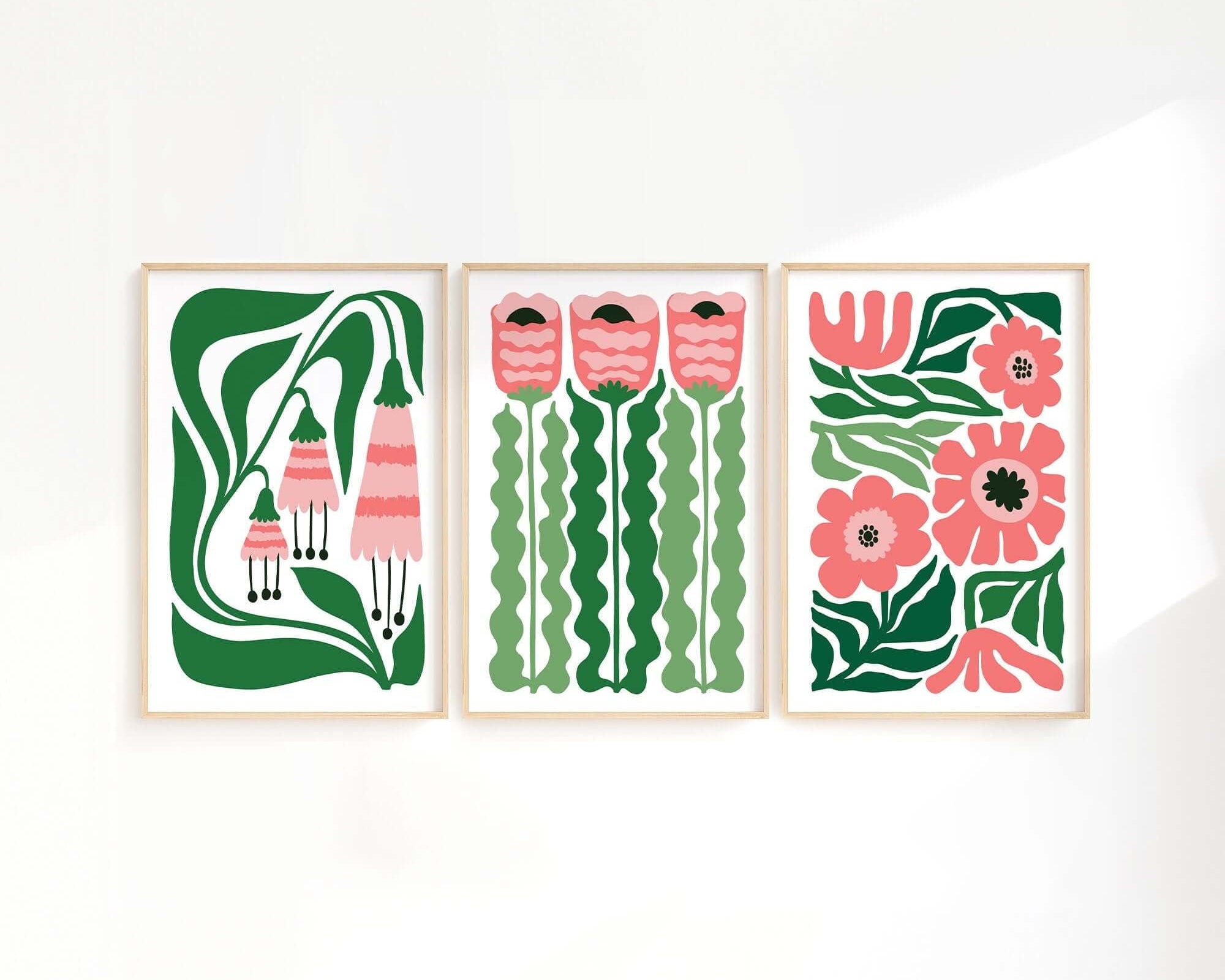 The Tropical Blocks Triptych (Set of Three Prints | 414) features abstract pink and green floral designs, creating a striking wall art collection that beautifully elevates any home decor on a white wall.
