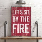 a red sign that says let's sit by the fire