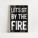 a black and white sign that says let's sit by the fire