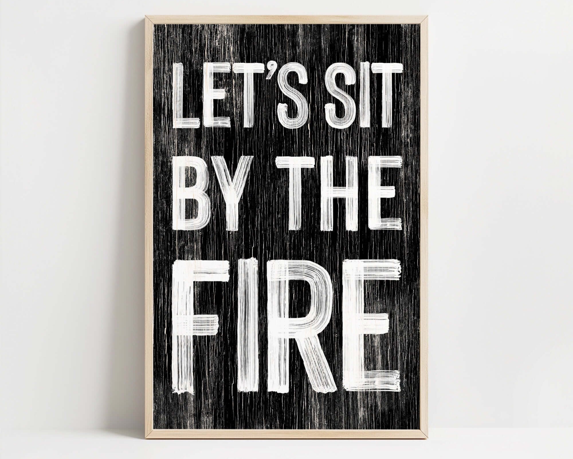 a black and white sign that says let's sit by the fire