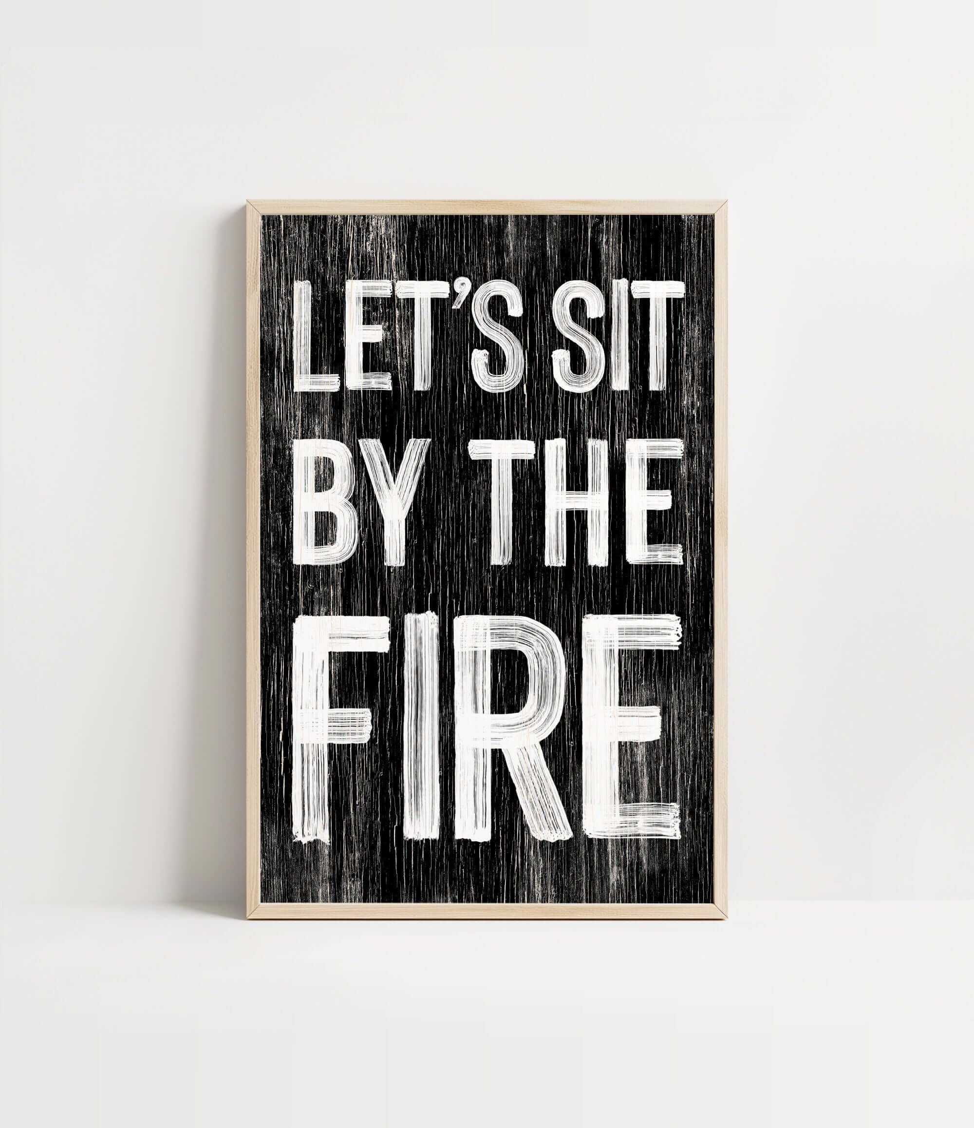 a black and white sign that says let's sit by the fire