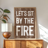 a wooden sign that says let's sit by the fire