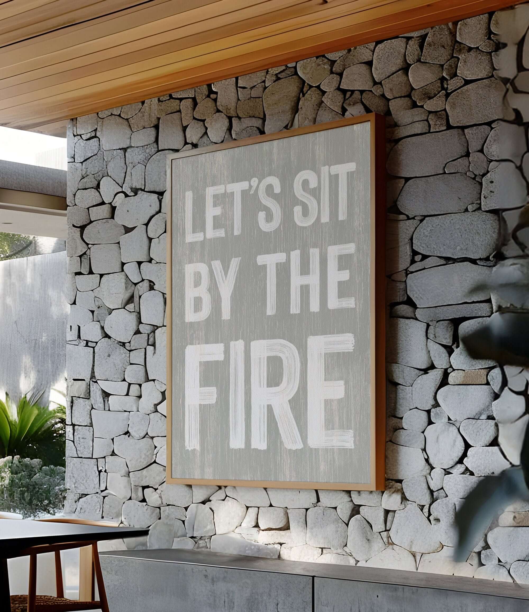 a sign on a stone wall that says let's sit by the fire