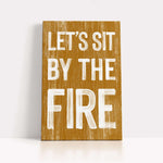 a wooden sign that says let's sit by the fire