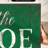 a hand holding a green sign that says the joe