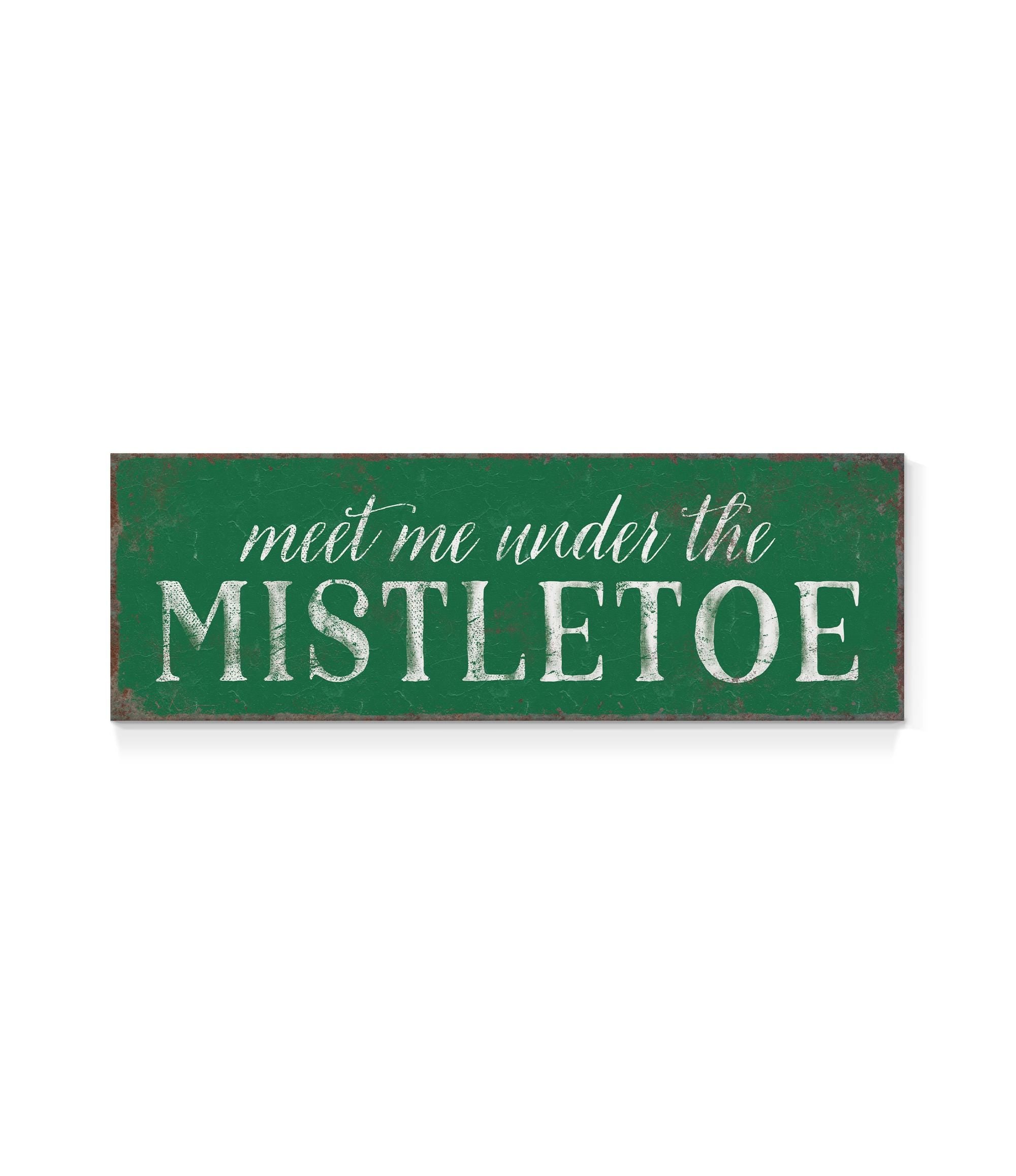 a green sign that says meet me under the mistletoe