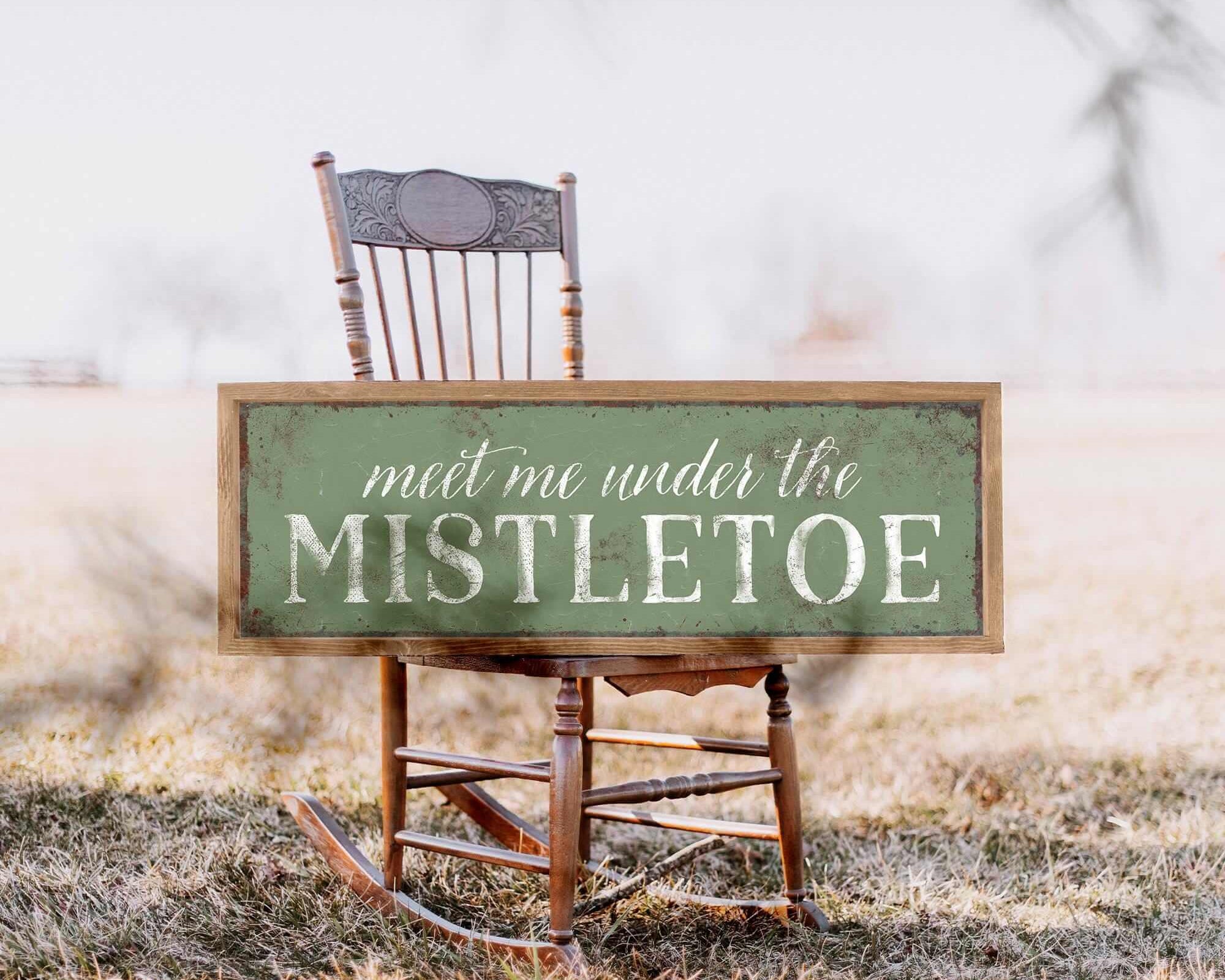 a table with chairs and a sign that says meet me under the mistletoe