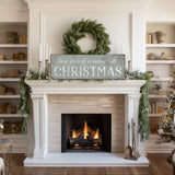 a fireplace with a christmas sign above it