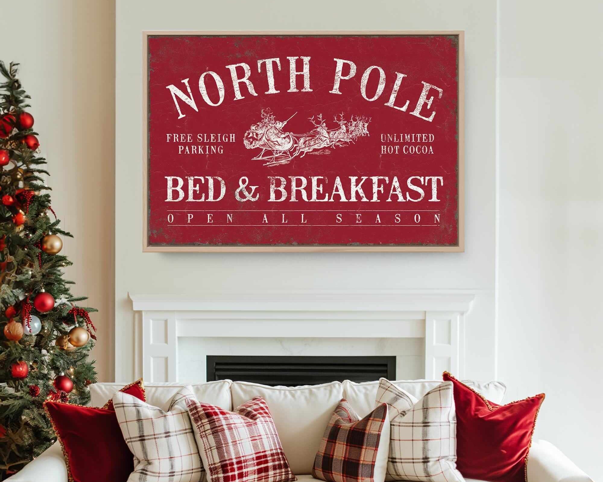 A festive living room with modern farmhouse decor features a Christmas tree and a dark red "North Pole Bed & Breakfast" sign above a white couch.