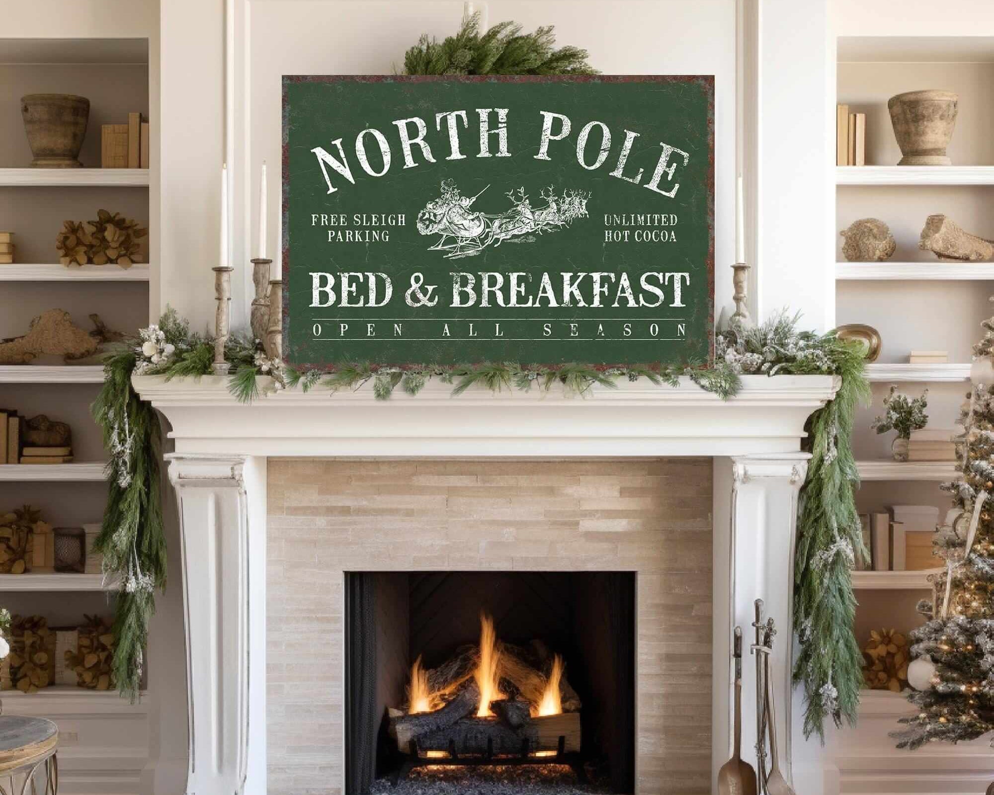 White fireplace with greenery and a large North Pole Bed & Breakfast Sign, Vine above, accented by holiday touches for cozy Christmas wall decor.