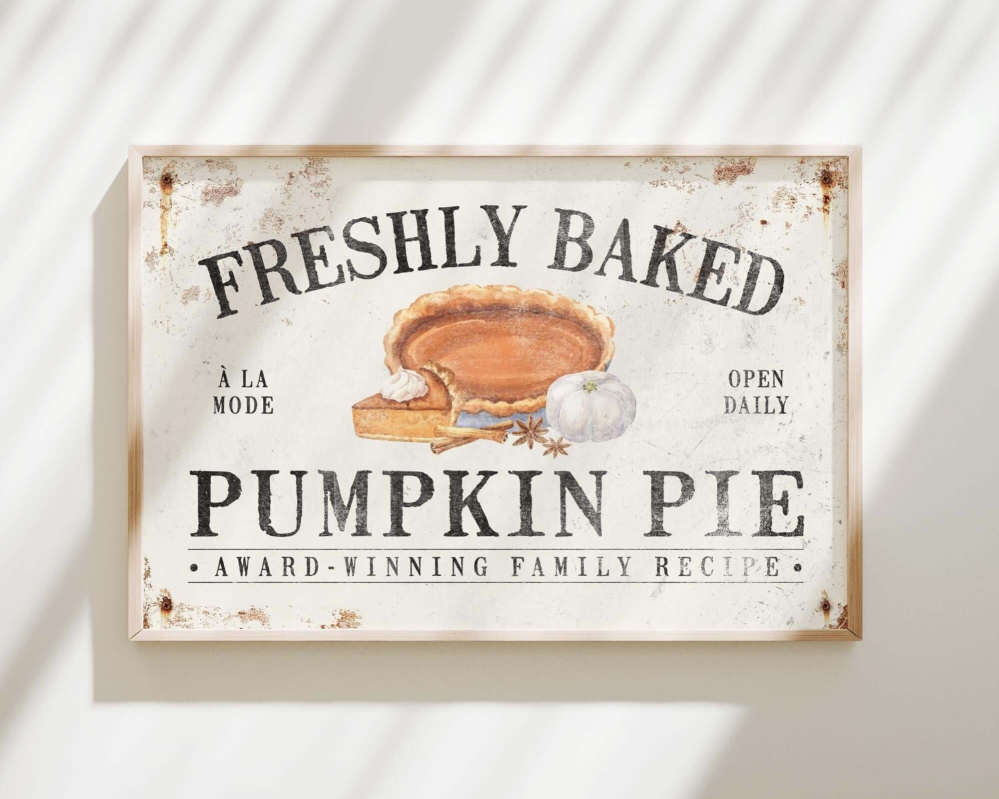 a sign hanging on a wall that says freshly baked pumpkin pie
