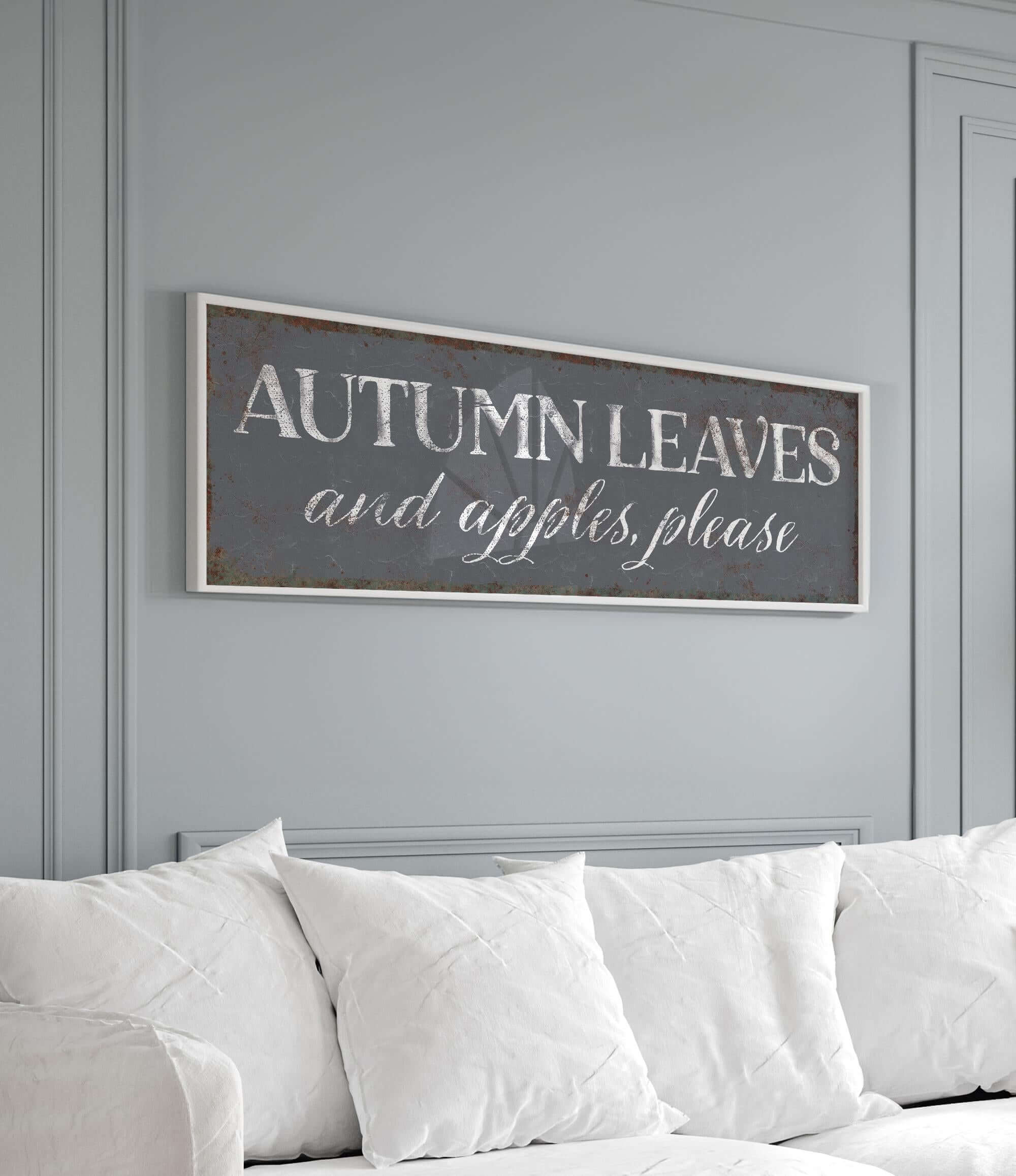 a living room with a white couch and a sign that says autumn leaves and apples