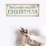 a woman holding a potted plant in front of a christmas sign